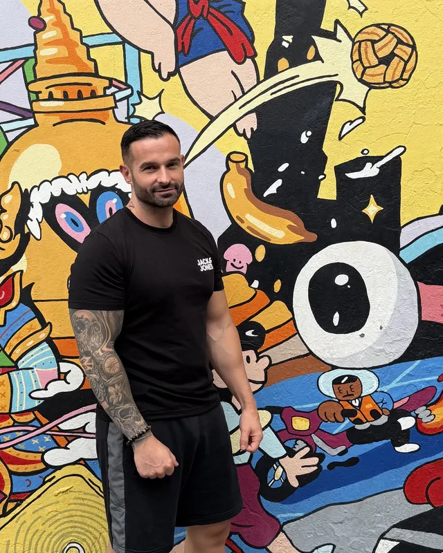 Antonio, creador de MyTailand, junto a un mural de Talat Noi en Bangkok