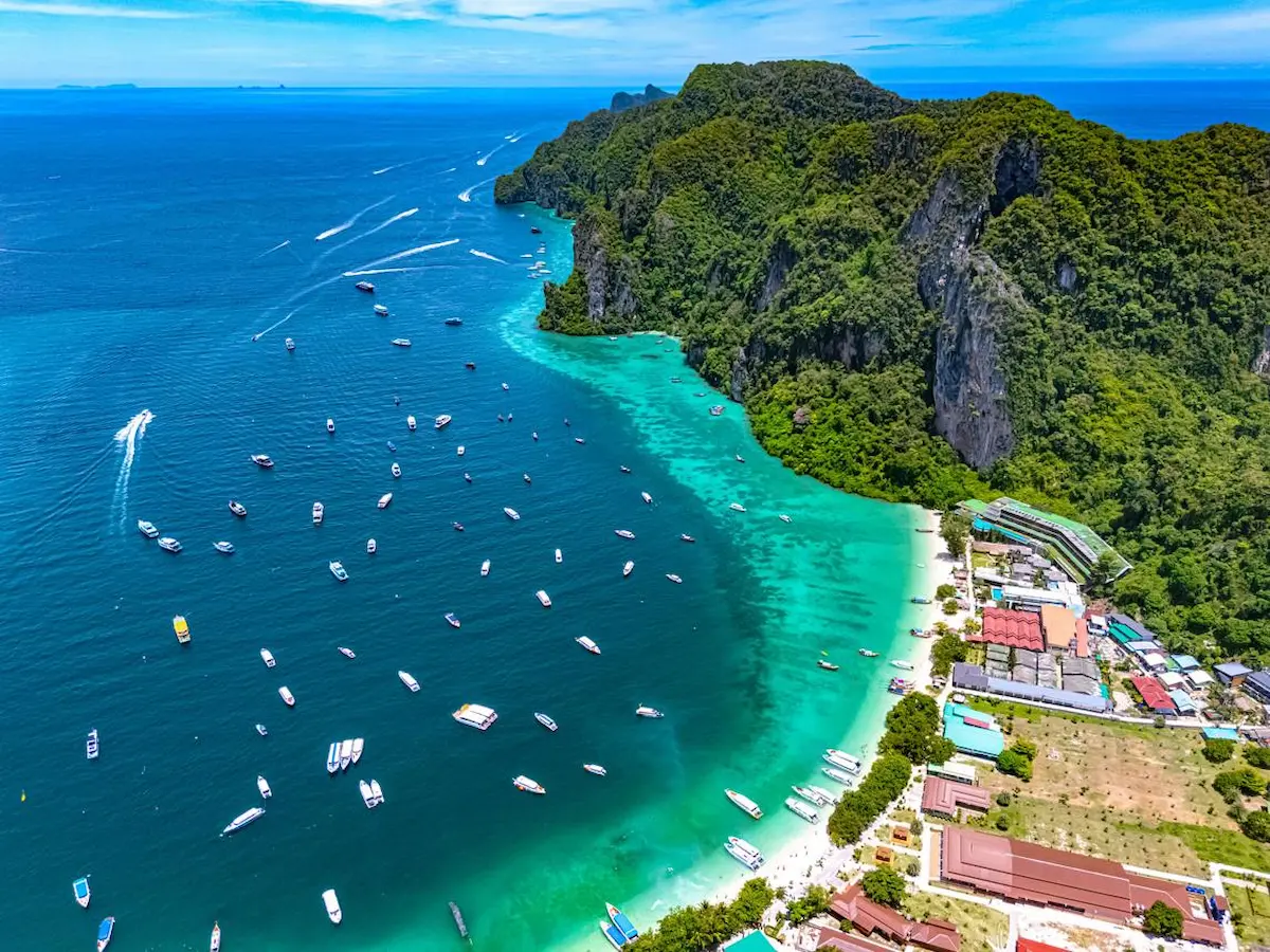 Barcos llegando a Koh Phi Phi entre acantilados y agua turquesa en el mar de Andamán