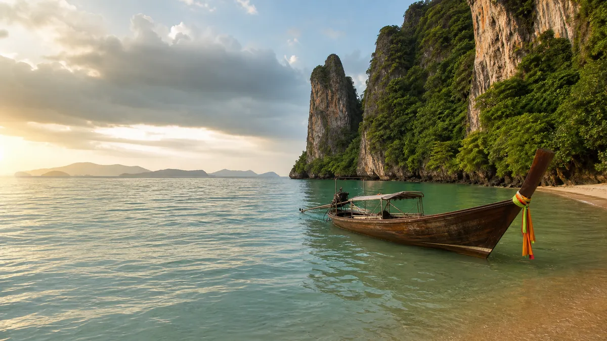 Barca tradicional long-tail ante los acantilados tropicales de Tailandia